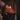 Heart-shaped candle on a stand with a lit candle in the background