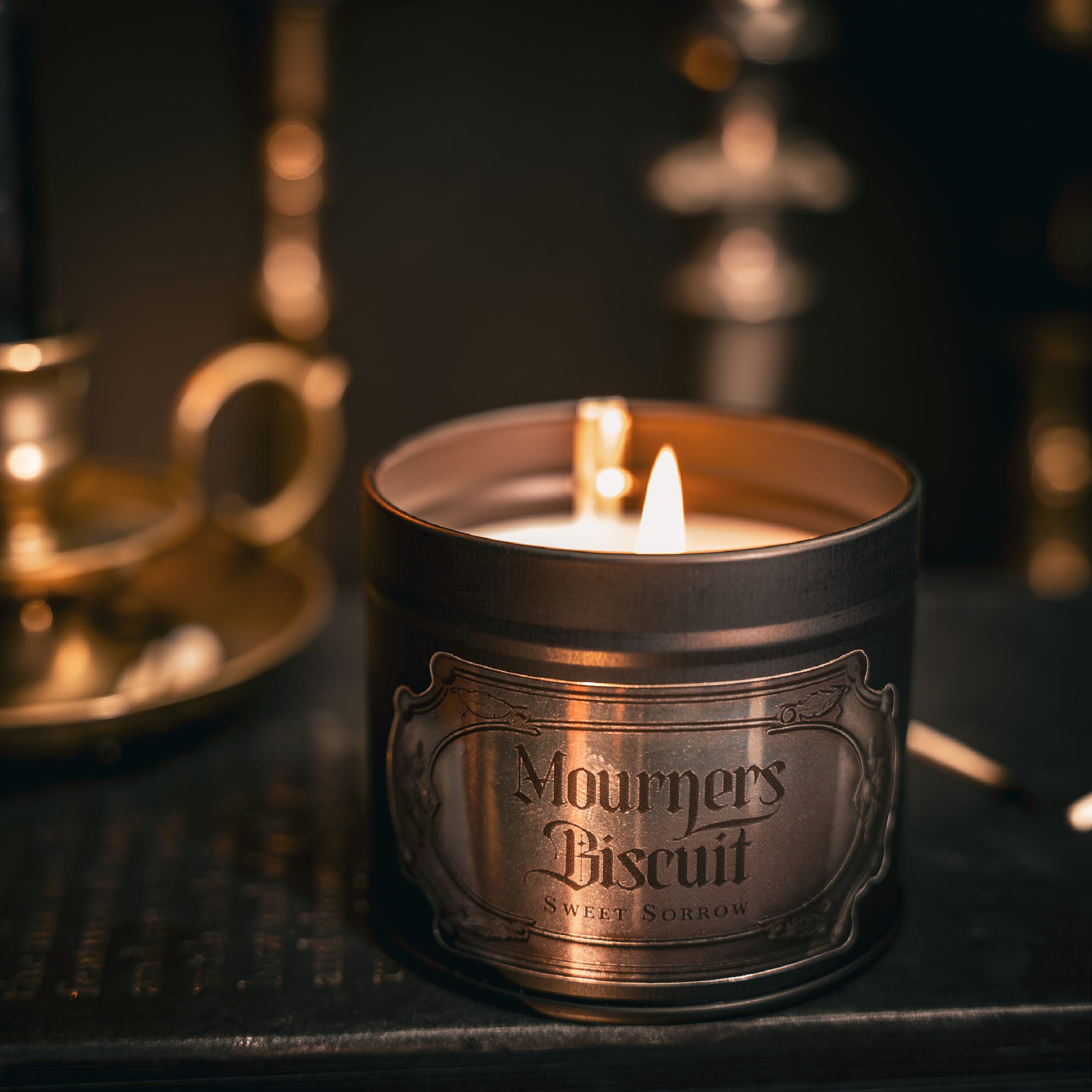 https://www.theblackenedteeth.com/cdn/shop/files/mourners-biscuit-tin-candle-scenejpg.jpg?v=1697792015